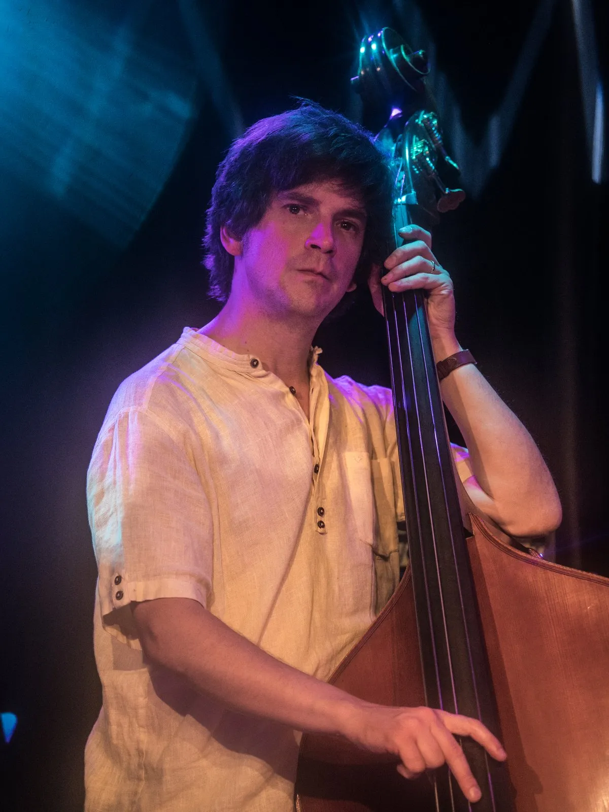 Dave O'Brien playing double bass under blue stage light